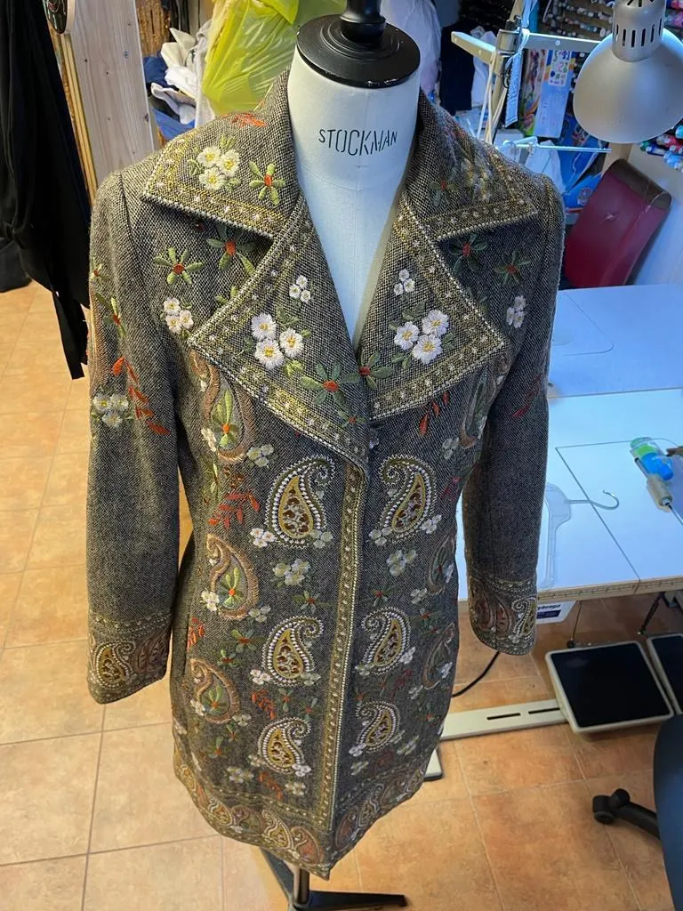 Embroidered coat on a mannequin in the atelier