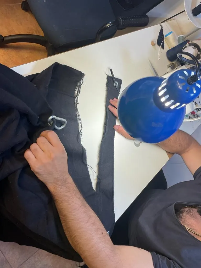 Handarbeit an einer Hose unter der Arbeitslampe
