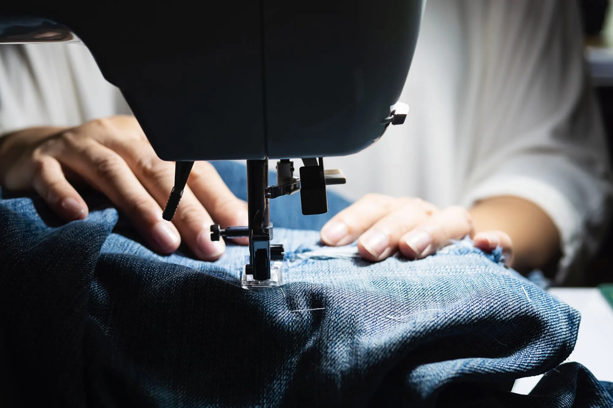 Jeans repareren op de naaimachine