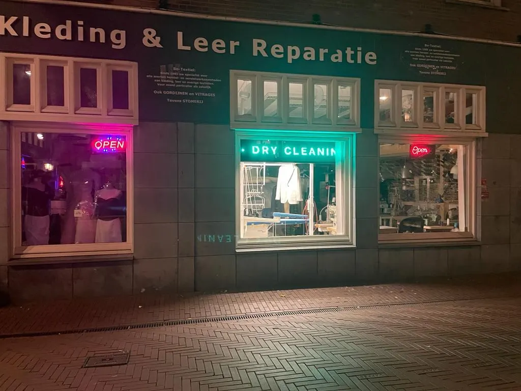 Das Geschäft am Abend mit beleuchtetem Dry-Cleaning-Schild